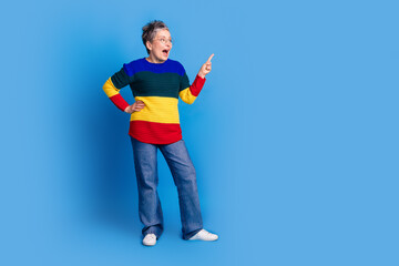 Photo of glad cheerful nice senior woman wear trendy striped clothes look empty space isolated on blue color background