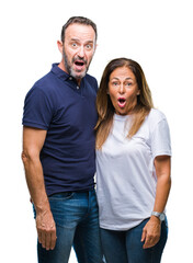 Middle age hispanic casual couple over isolated background afraid and shocked with surprise expression, fear and excited face.