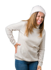 Beautiful middle age woman wearing winter sweater and hat over isolated background Suffering of backache, touching back with hand, muscular pain