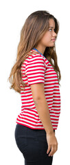 Young beautiful brunette woman wearing stripes t-shirt over isolated background looking to side, relax profile pose with natural face with confident smile.