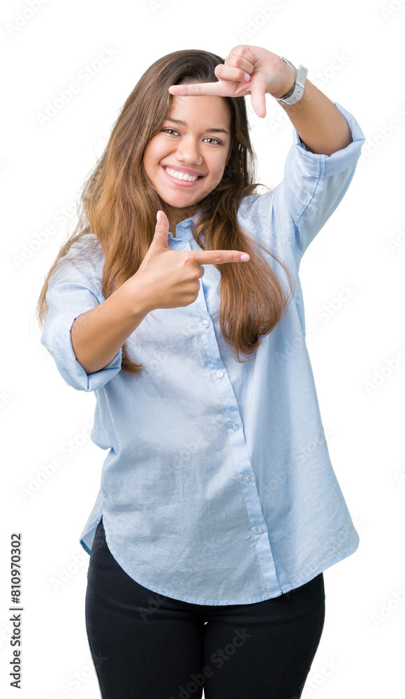 Sticker Young beautiful brunette business woman over isolated background smiling making frame with hands and fingers with happy face. Creativity and photography concept.