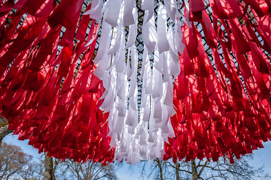 Abstract flag of Latvia made of ribbons against the sky. Happy independence day of Latvia. Flag background.