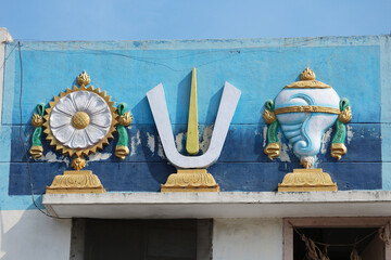 Chakra disc, Vaishnava Tilak and Shankha conch - symbols attributes of God Vishnu on the wall of a...