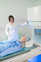 Woman doctor and patient in the MRI room.  female assistant preparing adult female patient for MRI scan	