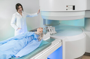 Woman doctor and patient in the MRI room.  female assistant preparing adult female patient for MRI scan	