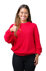 Young beautiful brunette woman wearing red winter sweater over isolated background doing happy thumbs up gesture with hand. Approving expression looking at the camera showing success.