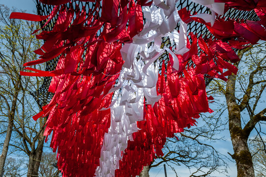 Abstract flag of Latvia made of ribbons against the sky. Happy independence day of Latvia. Flag background. - Powered by Adobe