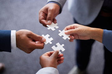 Businesspeople, collaboration and puzzle with hands in office for teamwork or synergy with joint effort. Group, corporate and partnership with unity in company or trust with employees in Germany.