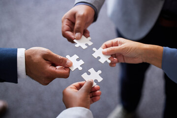 Businesspeople, collaboration and puzzle with hands in office for teamwork or synergy with joint...