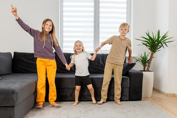 Three Children Playing and Dancing in Living Room