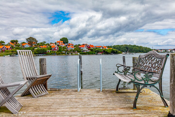 Scandinavian bench and chairs on wooden jetty in Karlskrona on Baltic sea coast, Sweden. Brandaholm neighbourhood