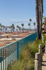 a scenic view over the beautiful coastline of oceanside with beautiful residential buildings and palm trees at a sunny day, california