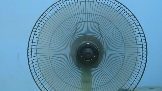Fan and air conditioner moving and unplugging waiting for a mechanic to come clean it summer is a must for hot asian people need air conditioner on a blue background