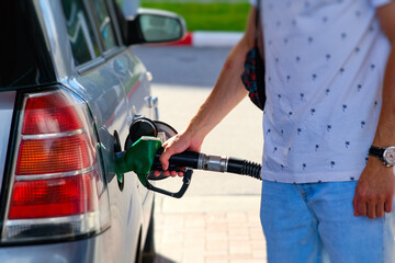 Young Man Refueling His Car at a Gas Station During a Sunny Afternoon