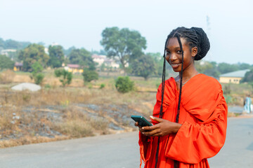 Happy African Woman in Red Dress Smiling, Holding Mobile Phone - Copy Space Image