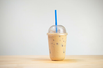 Iced coffee mocha or coffee latte in takeaway cup on wooden table. coffee package for takeaway, Cold beverage product.