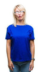 Fototapeta premium Young beautiful blonde woman wearing glasses over isolated background making fish face with lips, crazy and comical gesture. Funny expression.