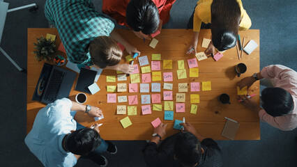 Top down view of smart diverse business people writing marketing idea at meeting and brainstorming...