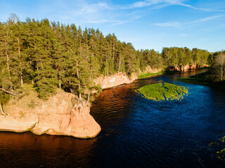 aerial view of the striking red cliffs and lush forests along a curving river Salaca in latvia