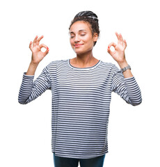 Young braided hair african american girl wearing sweater over isolated background relax and smiling with eyes closed doing meditation gesture with fingers. Yoga concept.