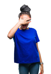 Fototapeta premium Young braided hair african american girl wearing glasses over isolated background peeking in shock covering face and eyes with hand, looking through fingers with embarrassed expression.