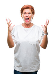 Atrractive senior caucasian redhead woman over isolated background crazy and mad shouting and yelling with aggressive expression and arms raised. Frustration concept.