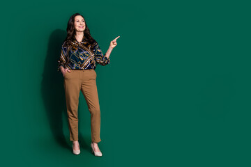 Photo of cheerful pretty lovely senior lady wear stylish clothes recommend empty space isolated on dark green color background