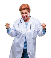 Senior caucasian doctor woman wearing medical uniform over isolated background very happy and excited doing winner gesture with arms raised, smiling and screaming for success. Celebration concept.