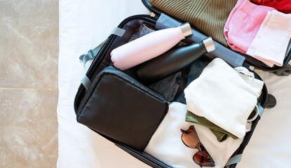 opened packed suitcase on bed in hotel room