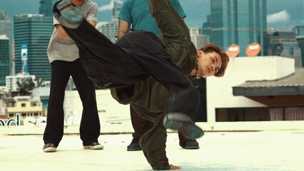 Professional asian break dancer practice B boy dance while multicultural friends at rooftop. Young...