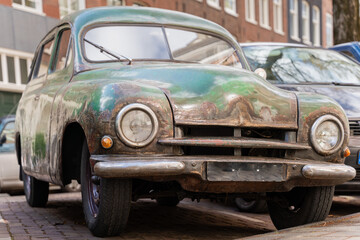 Front view of rusty oldtimer car Skoda 1200 from 1953. An old abandoned family car.