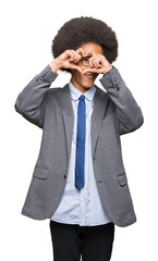 Young african american business man with afro hair wearing glasses Doing heart shape with hand and fingers smiling looking through sign