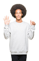 Young african american man with afro hair wearing sporty sweatshirt showing and pointing up with...