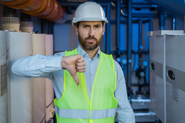 Young architect man wearing contractor helmet with angry face, negative sign showing dislike with...