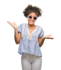 Young afro american woman wearing glasses over isolated background clueless and confused expression...