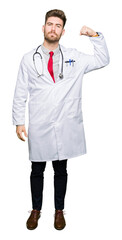 Fototapeta premium Young handsome doctor man wearing medical coat Strong person showing arm muscle, confident and proud of power