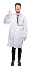 Fototapeta premium Young handsome scientist man wearing glasses smiling positive doing ok sign with hand and fingers. Successful expression.