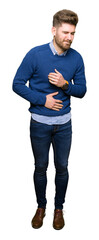 Young handsome bussines man with hand on stomach because nausea, painful disease feeling unwell. Ache concept.