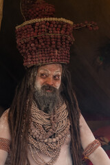 Portrait of an holy male naga sadhu baba with ash on his and long hairs wearing rudraksha necklace...