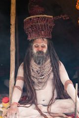 Portrait of an holy male naga sadhu baba with ash on his and long hairs wearing rudraksha necklace...