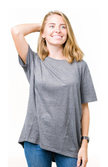 Fototapeta premium Beautiful young woman wearing oversize casual t-shirt over isolated background Smiling confident touching hair with hand up gesture, posing attractive