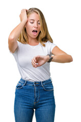 Beautiful young woman wearing casual white t-shirt over isolated background Looking at the watch time worried, afraid of getting late