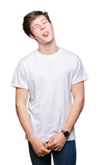 Young handsome man wearing casual white t-shirt over isolated background sticking tongue out happy with funny expression. Emotion concept.