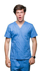 Obraz premium Young doctor wearing medical uniform over isolated background afraid and shocked with surprise expression, fear and excited face.