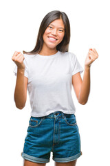 Young asian woman over isolated background celebrating surprised and amazed for success with arms raised and open eyes. Winner concept.