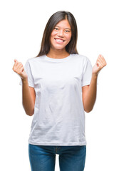 Young asian woman over isolated background celebrating surprised and amazed for success with arms...