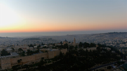 Fototapeta premium East Jerusalem walls and Arab neighborhoods at sunset Drone view from Jerusalem old city walls, may 2022