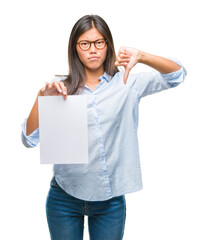 Young asian woman over isolated background holding blank paper with angry face, negative sign...