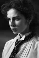 Black and white portrait of a girl in white shirt and tie. Graine effect used