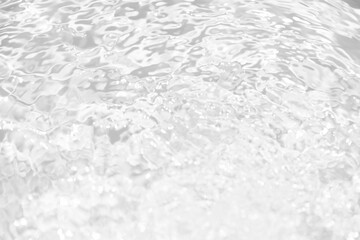White water with ripples on the surface. Defocus blurred transparent white colored clear calm water surface texture with splashes and bubbles. Water waves with shining pattern texture background.